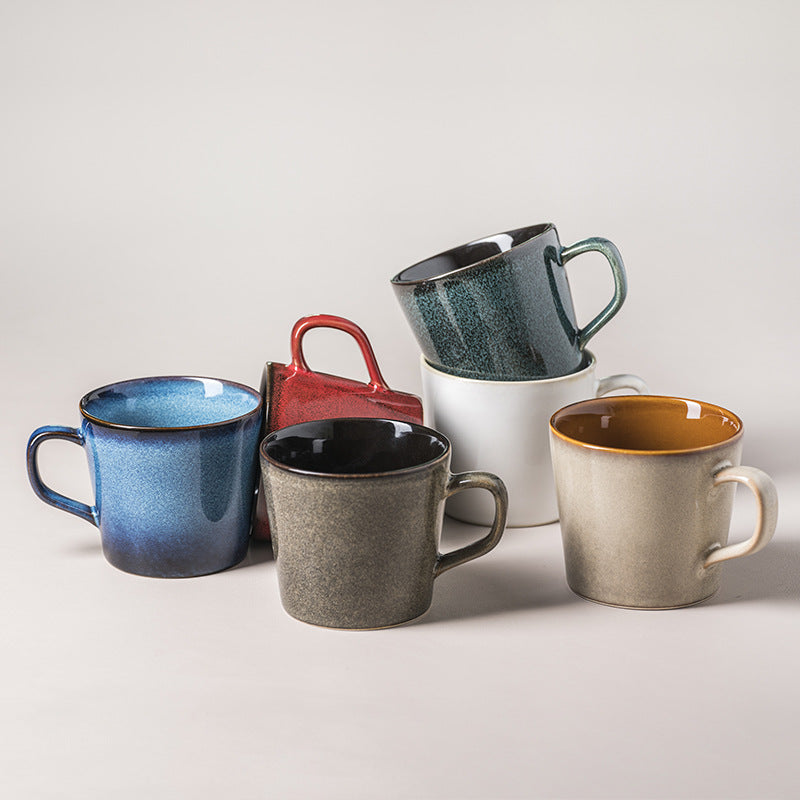 Set of colorful ceramic mugs on a light gray background